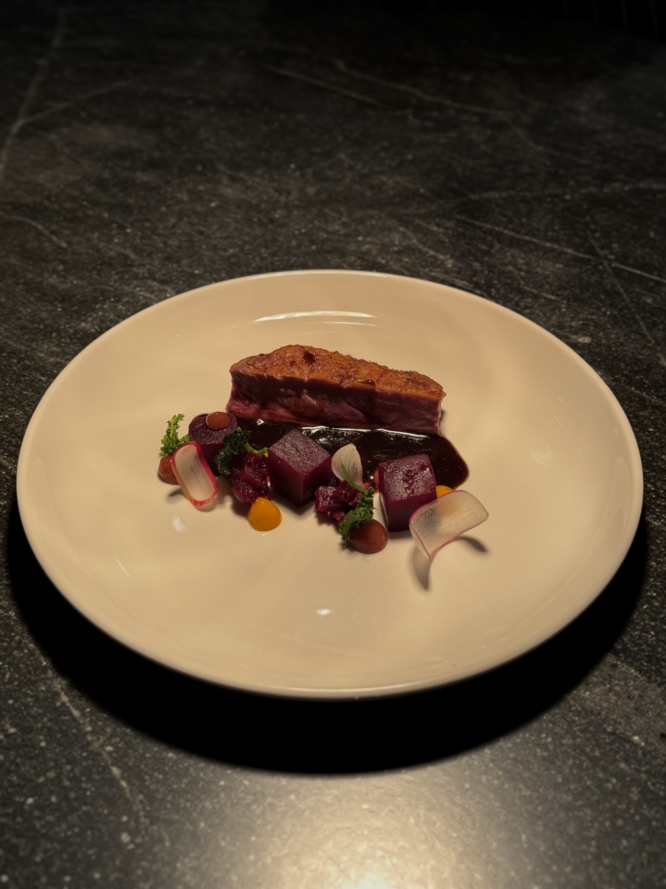 A plated dish of duck, beetroot and blackberry jus